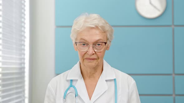 Senior short haired female doctor in white robe alt
