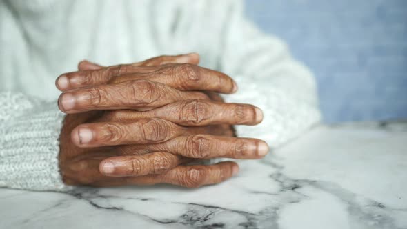 a Nervous Senior Women Hand on Table alt