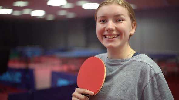 Portrait of a smiling young girl table tennis player with a ping pong racket alt