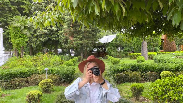 Photographer Takes a Pictures on a Camera in the Garden