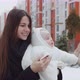 Joyful Young Mother Walks Down The Street In Winter, Holding A Baby - VideoHive Item for Sale
