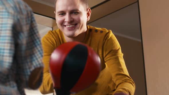 Caucasian man helping his son to fight with punching bag