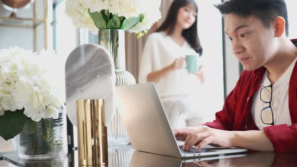asian wife serving coffee and embracing asian husband alt