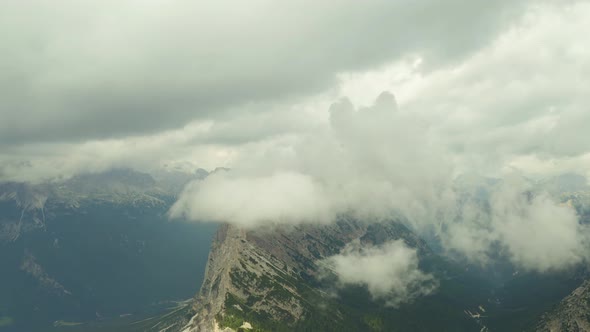 Fly towards clouds rocky mountain range, dolomites south tyrol italy alt