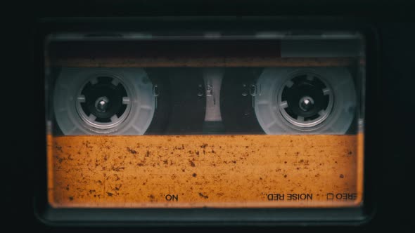 Vintage Yellow Audio Cassette Playing in Deck of an Old Tape Recorder alt
