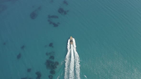 Epic Drone Shot of a Yacht Crossing the Transparent Ocean Water and Making Waves