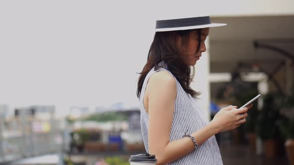 Beautiful Asian girl using smartphone at community mall.