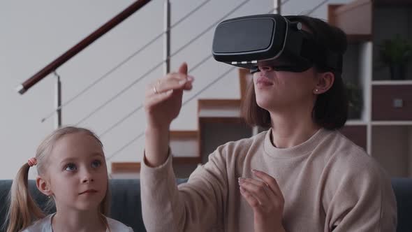 Mother in 3d Virtual Reality Glasses Sitting Near Her Little Dau
