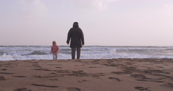 Young Girl Playing By the Sea with Her Grandfather