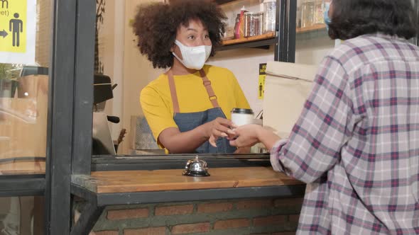 Female barista works in with face mask, new normal service of cafe in COVID-19. 