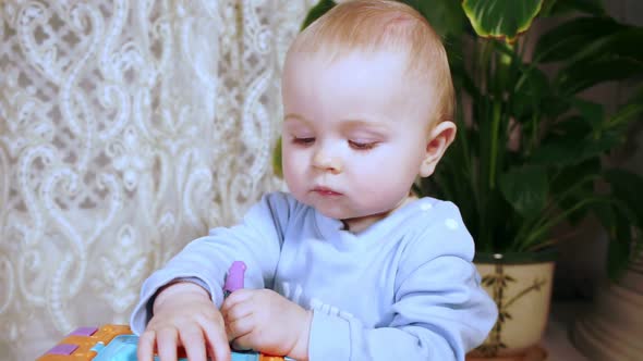 Baby Taps Her Hand on Developing Cube Then Looks at Camera and Smiles Sweetly