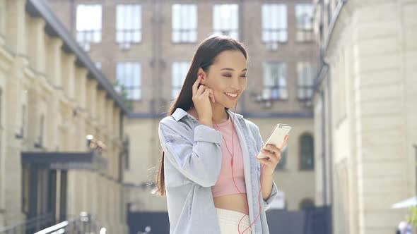 Woman standing with smartphone.