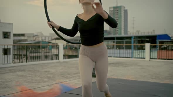 Woman in sportswear stretching and warm up before doing yoga on the rooftop in the evening. alt
