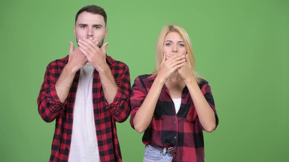 Young Couple Covering Mouth Together As Three Wise Monkeys Concept