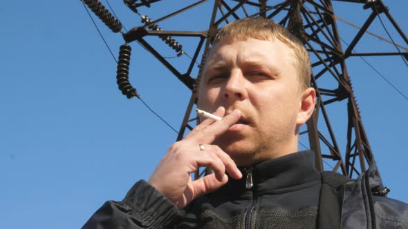 Portrait of Adult Serious Man Looking Into Camera and Smoking Cigarette Outdoor alt