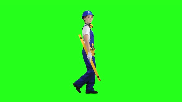 Girl Is Wearing a Yellow Building Level. Green Screen. Side View alt