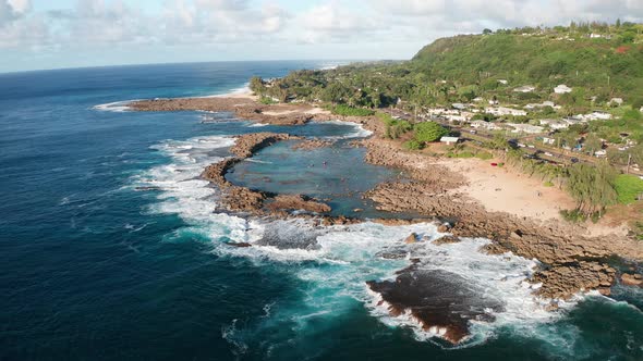 Descending close-up aerial shot of snorkelers and swimmers in Shark Cove on the North Shore of O'ahu alt