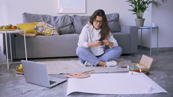Happy Woman Texts Message Near Paper and Laptop on Floor