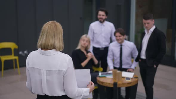 Back View Woman Presenting Business Idea on Office Terrace with Blurred Employees Clapping in Slow alt