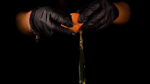 Man Hands in Gloves Break Egg Cooking Tasty Dish on Black alt