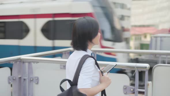 Portrait of asian woman with earphone listening music and using smartphone for chatting