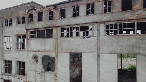 Aerial view of abandoned industrial buildings. Drone flies over an abandoned factory. alt