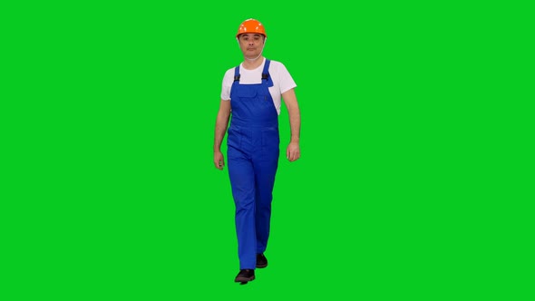 Asian Worker In Blue Uniform And Hardhat Walking Slowly on Green Screen