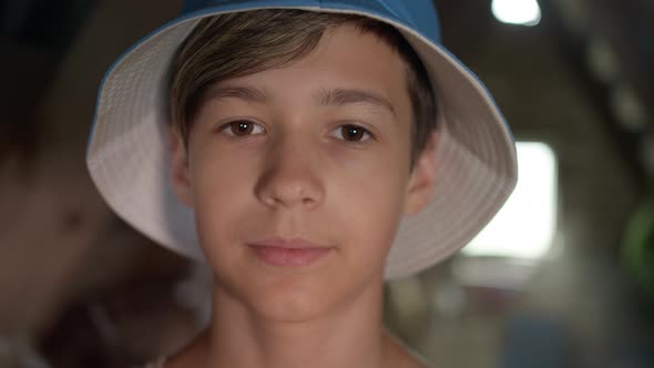 Portrait of a Happy Boy in a Blue Hat Looking at the Camera and Smiling
