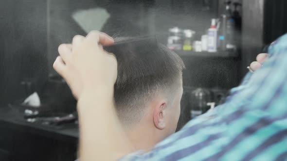 Professional Barber Wetting and Combing Hair of a Male Client