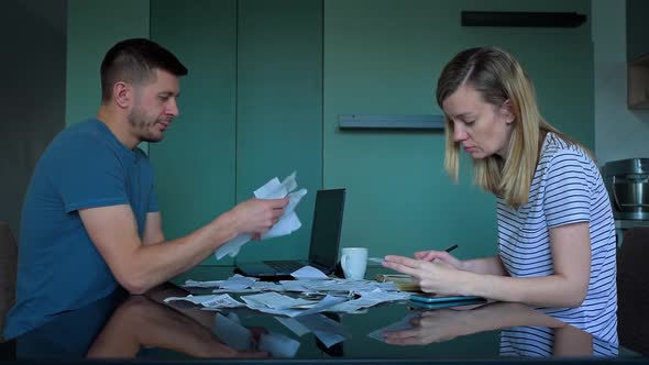 Man and Woman Looking at Payment Bills in the Kitchen alt