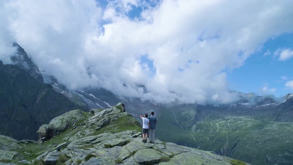 Wanderlust Moving Backward Over Two People Looking at Mountain Valley in Sunny Summer with Clouds