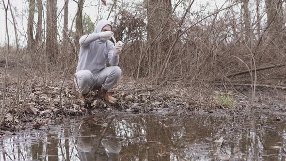 An ecologist takes a water test in a river. alt