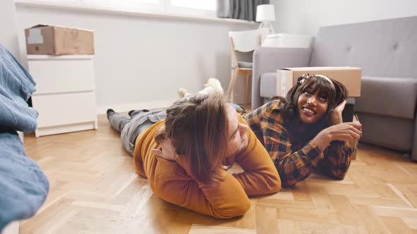 Young Happy Couple Relaxing on the Floor of the New Appartment alt