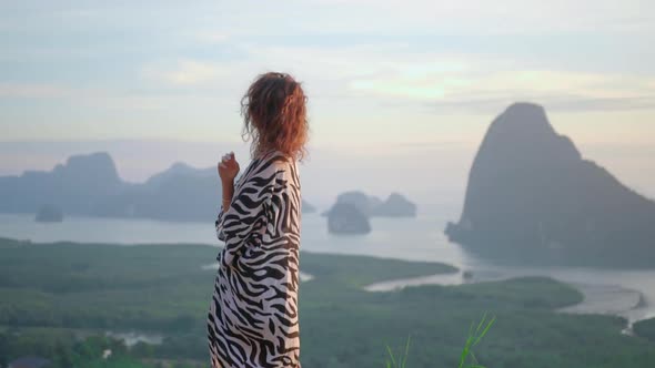 Woman Enjoys Sunset on Mountain Pick She Looks From the Top To Amazing Bay alt