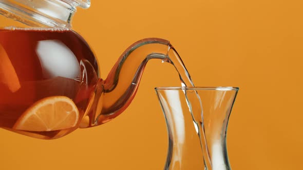 Pouring Citrus Black Tea on Orange Background alt