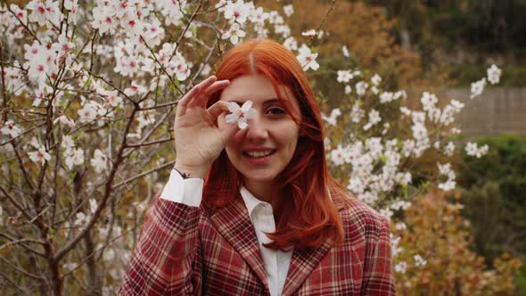 Happy Redhaired Girl Under Spring Flower Tree alt