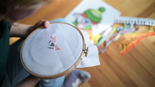 canvas with embroidery, female hands and an example in the background alt