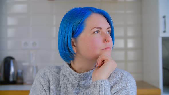 Millenial girl with colored blue hair thinking about solution in closeup 4k video clip alt