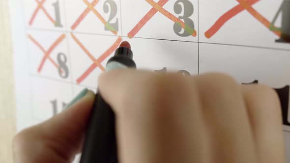 Female Hand Crosses with Red Marker the Calendar Day 10. Slow Motion Shot. Close Up