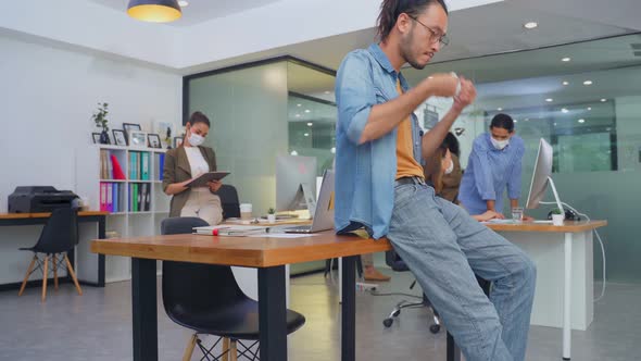 Group of Asian young business people working on computer in office with new normal lifestyle. alt