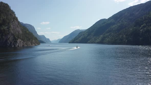 Aerial shot following a speedboat through Mesmerizing Norwegian fjord Scene alt