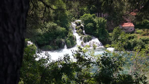 A beautiful multi-level waterfall cascades down into the turquoise river alt