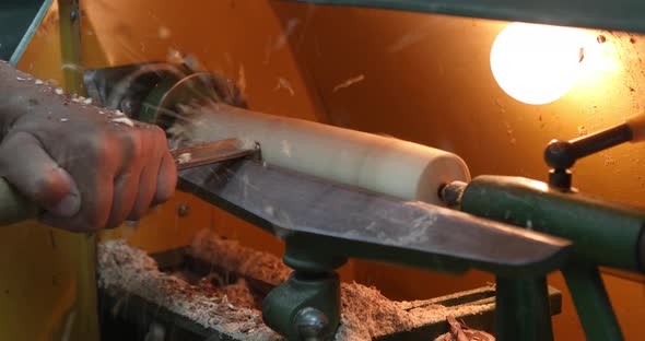 Woodworker carving a wooden bowl. Joinery. Carpenter with a cutter works on a wooden lathe