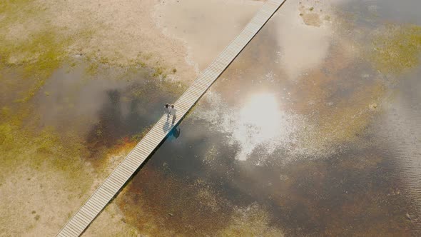 Couple are walking on a beautiful wooden bridge Summer Baikal lake Olkhon island alt