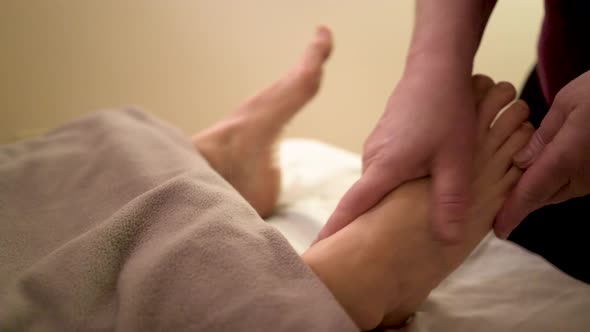 Using a type of ointment a massage therapist works on loosening up the muscles and tendons in a matu alt