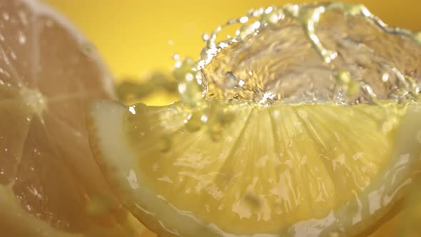 Slow Motion Shot of Lemon Juice Splashing Through Lemon Slices alt
