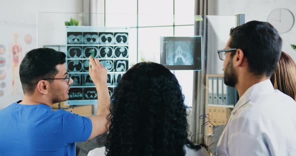 Doctors Consulting About Further Treatmant of Patient Checking His X-ray and Scull Scan alt