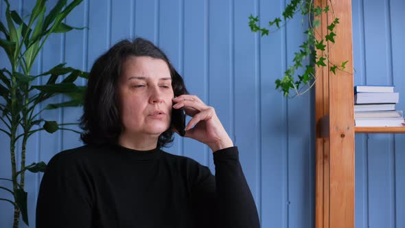 Middle Aged Business Woman Talking Mobile Phone at Home Office