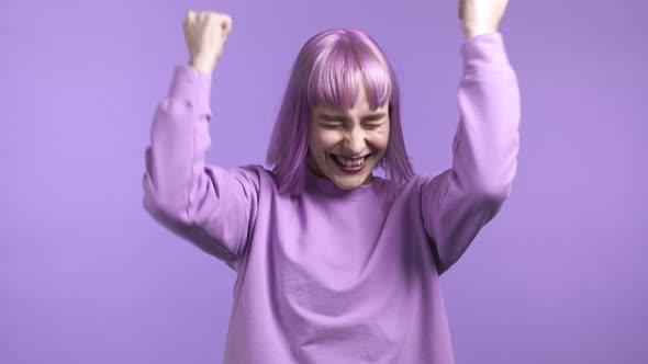 Woman with Dyed Purple Hair is Very Glad and Happy She Shows Yes Gesture of Victory She Achieved alt