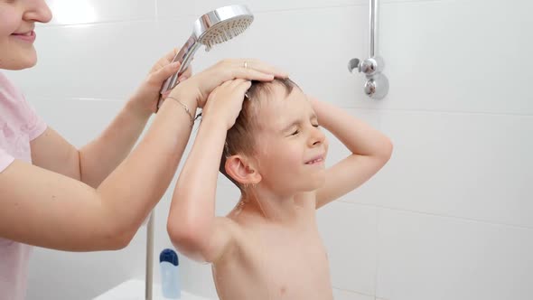 Little Boy with Mother Rubbing His Head and Washing Hair with Shampoo Under Shower alt